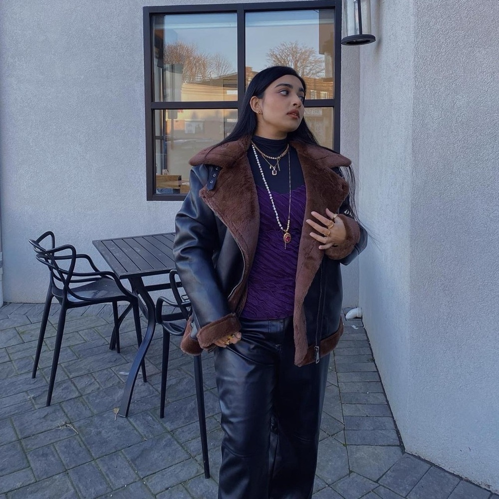 Black and brown faux leather jacket with a fur-lined hood